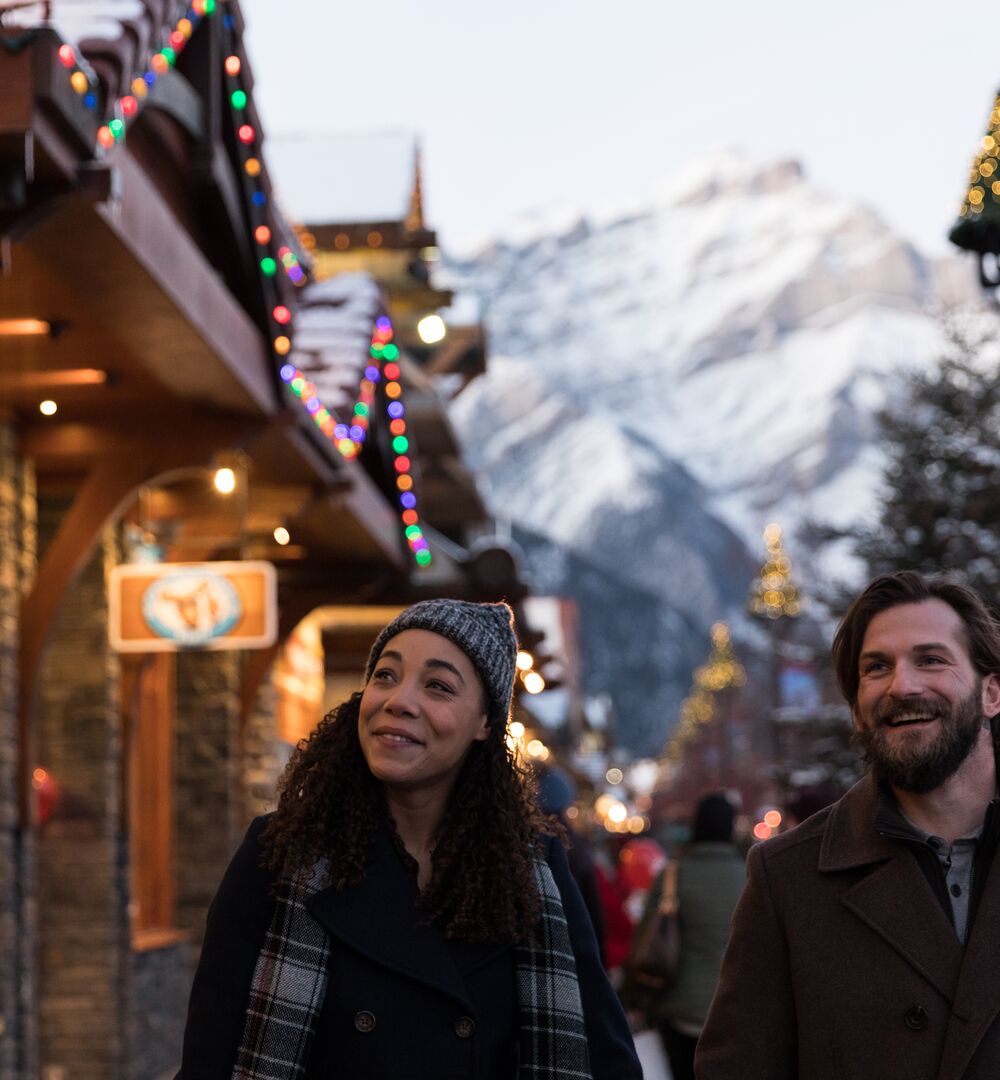 Two people walk down Banff Ave doing their Christmas and holiday shopping in Banff and Lake Louise.